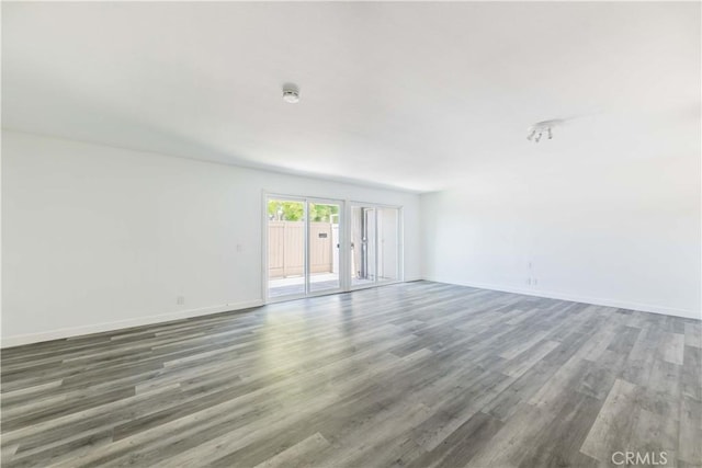 spare room featuring baseboards, french doors, and wood finished floors
