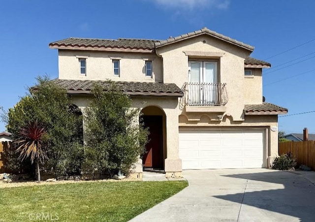 mediterranean / spanish house featuring driveway, stucco siding, an attached garage, and fence