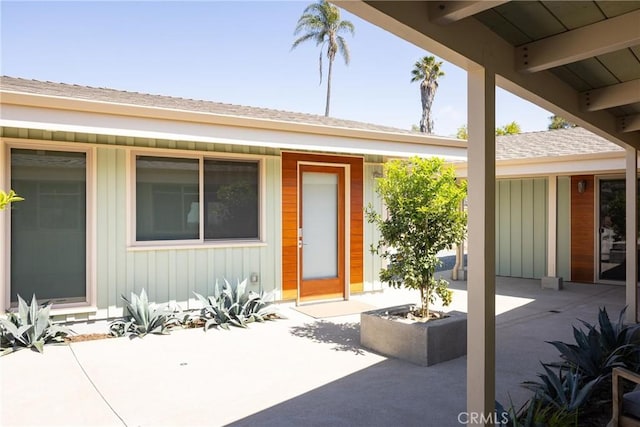 property entrance featuring a patio area and board and batten siding