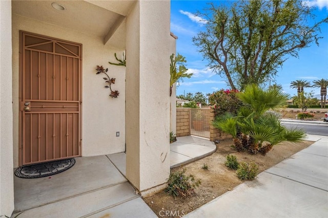 79260 Cool Reflection Ln, Quinta, CA 92253 - doorway to property featuring stucco siding and a gate