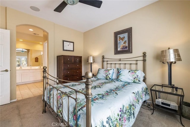 79260 Cool Reflection Ln, Quinta, CA 92253 - bedroom with carpet flooring, arched walkways, connected bathroom, a ceiling fan, and tile patterned flooring