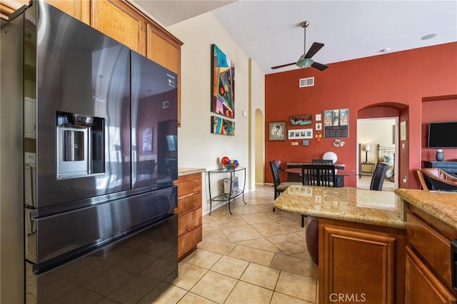 79260 Cool Reflection Ln, Quinta, CA 92253 - kitchen with fridge with ice dispenser, arched walkways, brown cabinets, ceiling fan, and light tile patterned flooring