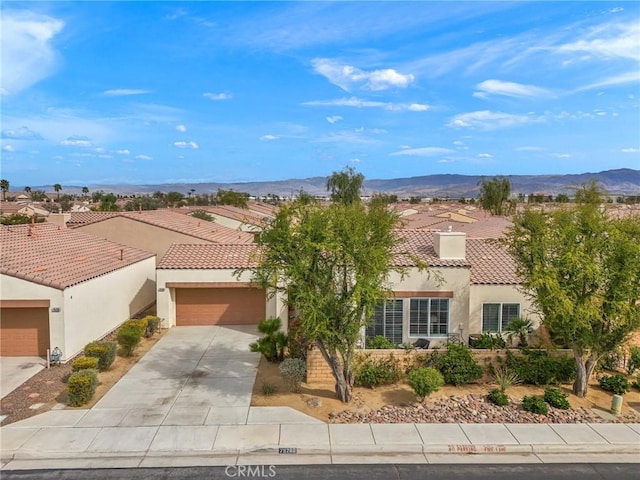 79260 Cool Reflection Ln, Quinta, CA 92253 - mediterranean / spanish-style home with a tile roof, stucco siding, an attached garage, driveway, and a mountain view