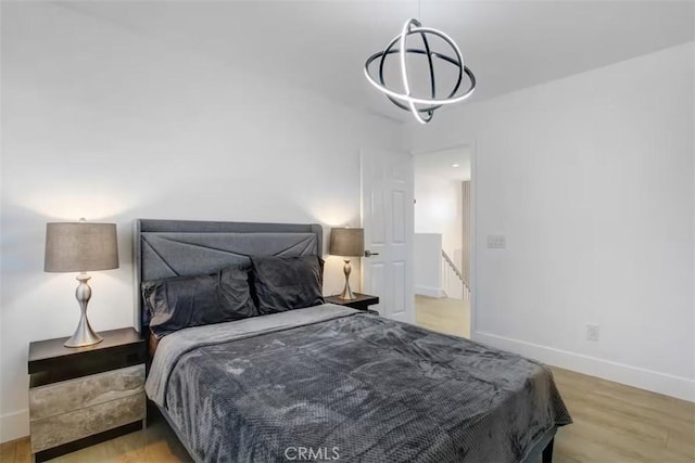 bedroom featuring wood finished floors and baseboards