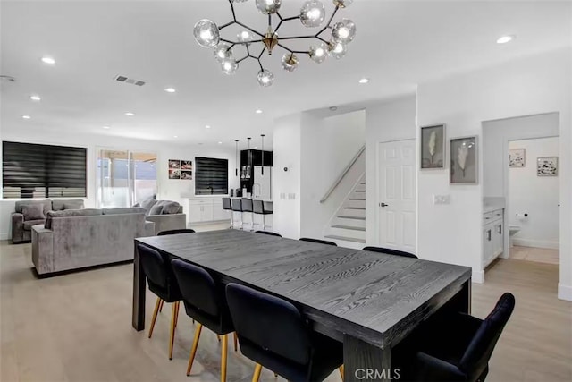 dining space featuring recessed lighting, light wood finished floors, visible vents, stairs, and a chandelier