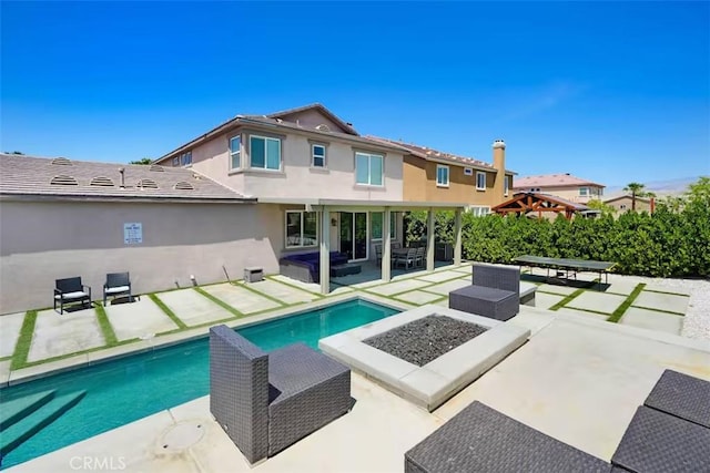 43118 Fiore St, Indio, CA 92203 - back of property with an outdoor living space with a fire pit, a patio, a fenced in pool, and stucco siding