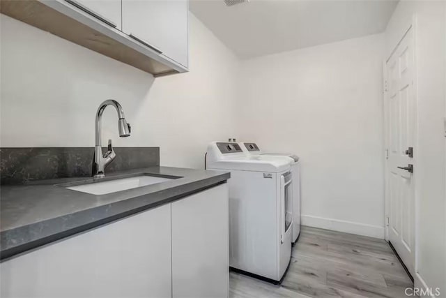 43118 Fiore St, Indio, CA 92203 - laundry room with a sink, cabinet space, separate washer and dryer, baseboards, and light wood-style floors