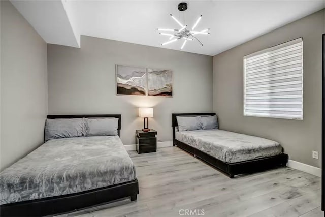 43118 Fiore St, Indio, CA 92203 - bedroom with a chandelier, baseboards, and wood finished floors