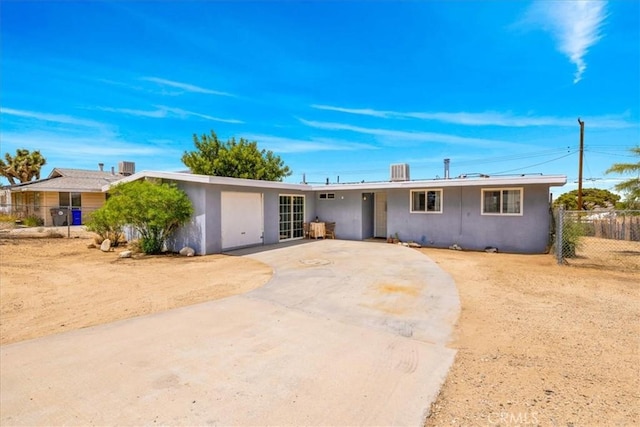 ranch-style house with stucco siding, driveway, and fence
