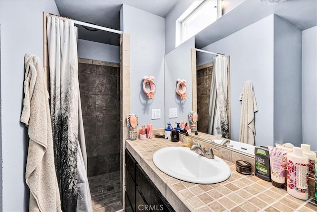 bathroom featuring vanity and tiled shower