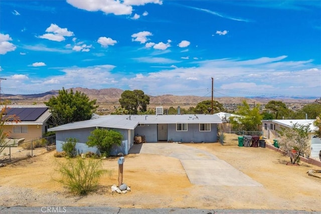 single story home featuring fence, stucco siding, a mountain view, and driveway