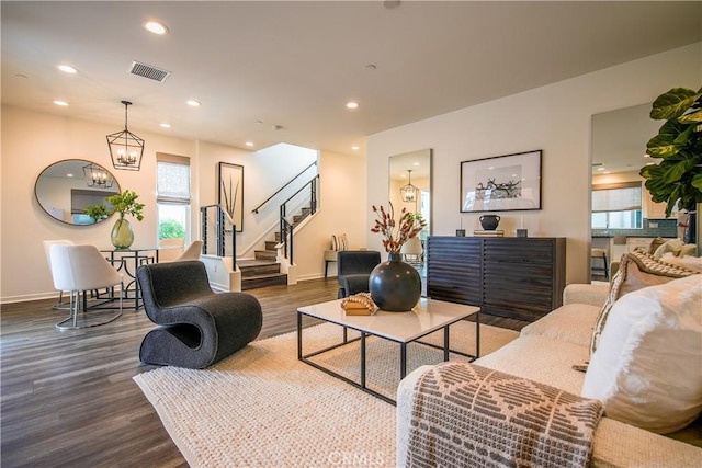 living room featuring baseboards, stairway, dark wood finished floors, and visible vents