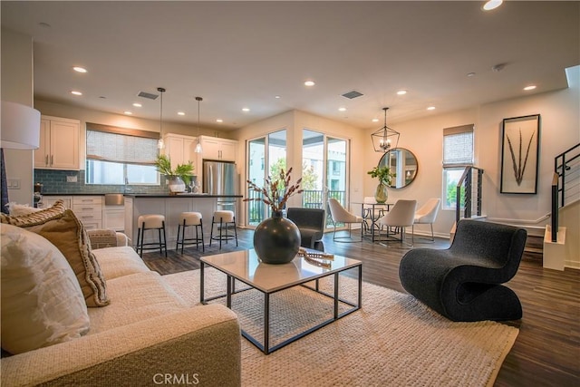 living area with dark wood-style floors, visible vents, and recessed lighting