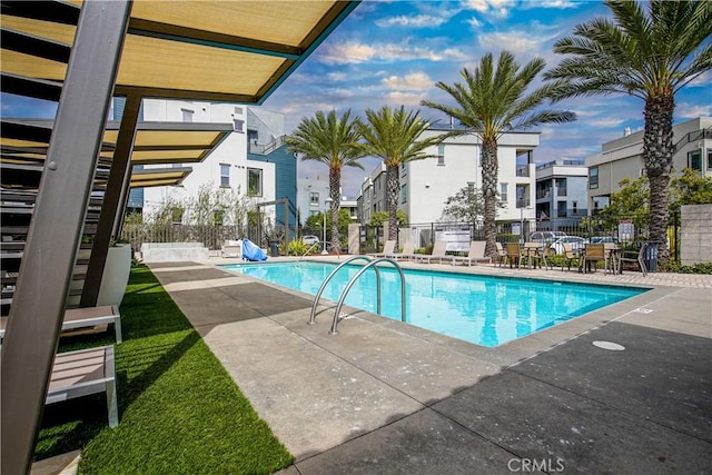 pool featuring fence, a patio area, and a residential view