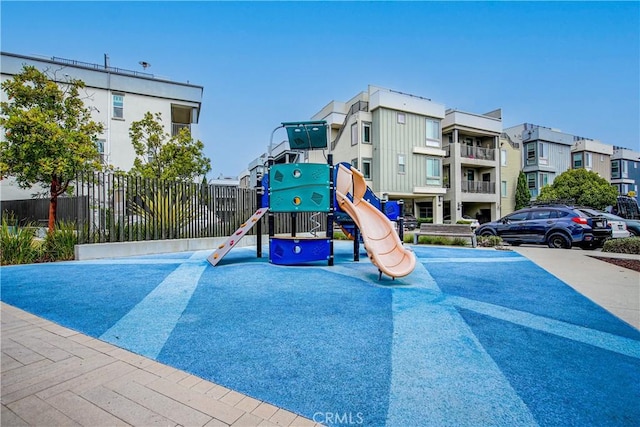 community playground with a residential view and fence