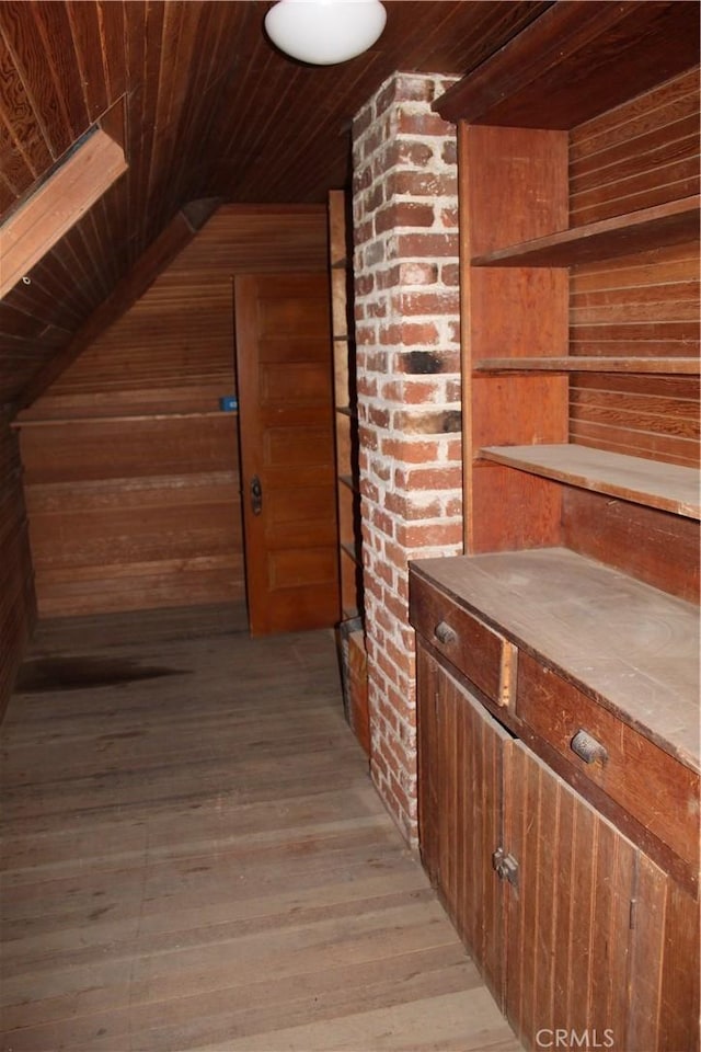 hall featuring lofted ceiling, wooden walls, wood ceiling, and light wood-style floors