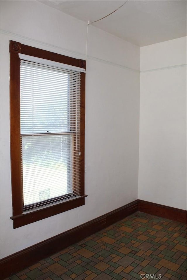 spare room with baseboards