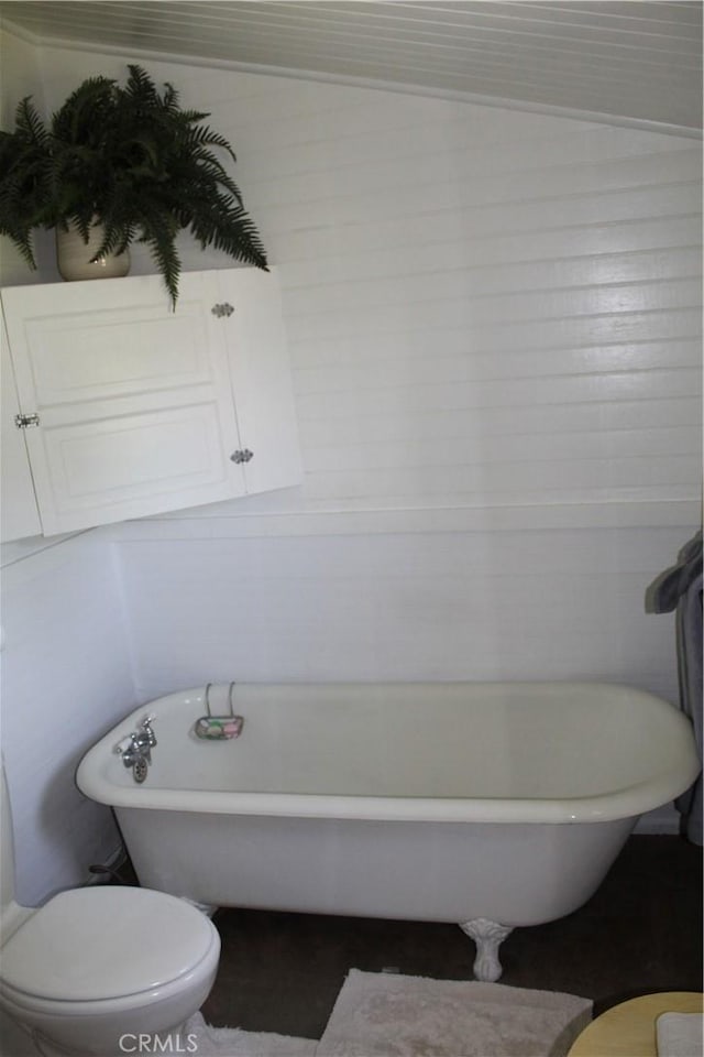 bathroom with toilet and a soaking tub
