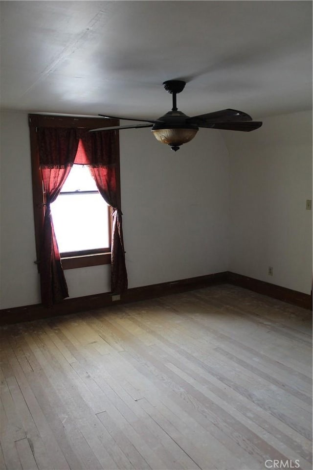 empty room with baseboards, ceiling fan, and hardwood / wood-style flooring