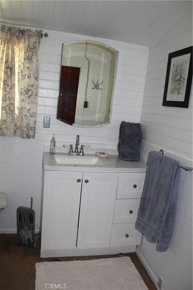 bathroom with vanity, wood walls, and wood ceiling