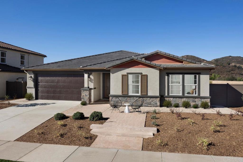 ranch-style house with driveway, stucco siding, a garage, and stone siding