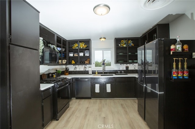 73881 Siesta Dr Unit 29, Palms, CA 92277 - kitchen featuring a sink, open shelves, black appliances, light wood finished floors, and light countertops