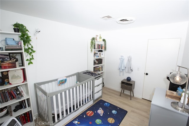 73881 Siesta Dr Unit 29, Palms, CA 92277 - bedroom with a nursery area, visible vents, and wood finished floors