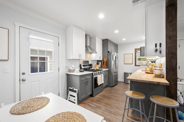 586 Del Mar Ave, Chula Vista, CA 91910 - kitchen with appliances with stainless steel finishes, wall chimney exhaust hood, recessed lighting, light wood-type flooring, and gray cabinetry