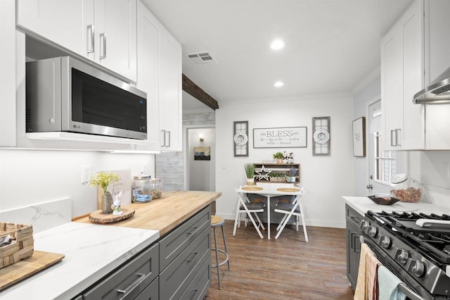 586 Del Mar Ave, Chula Vista, CA 91910 - kitchen with stainless steel microwave, wood finished floors, white cabinets, recessed lighting, and ornamental molding