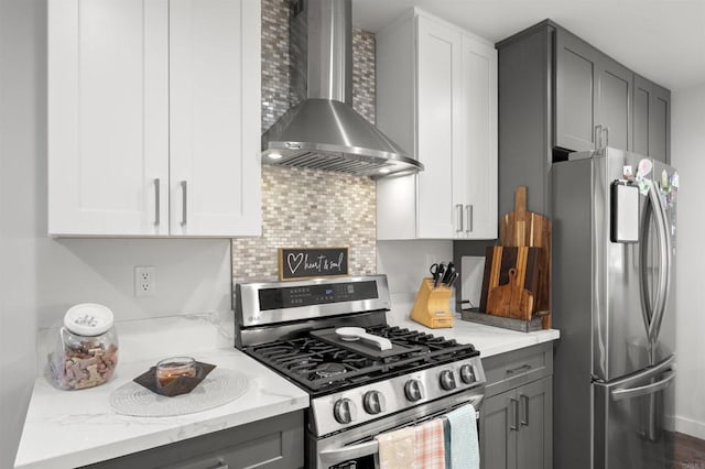586 Del Mar Ave, Chula Vista, CA 91910 - kitchen with appliances with stainless steel finishes, wall chimney range hood, gray cabinets, light stone counters, and decorative backsplash