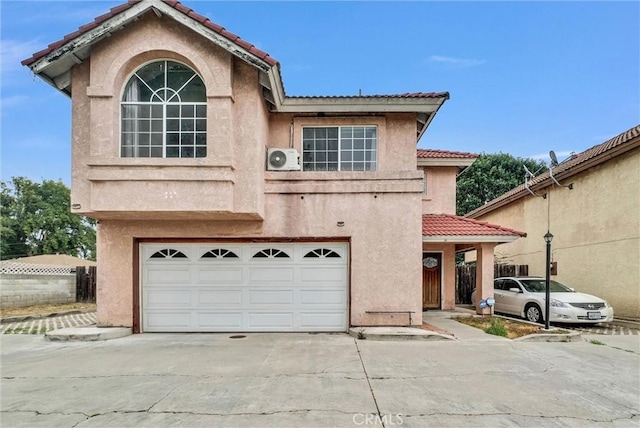 view of front of property with driveway, stucco siding, a tiled roof, and an attached garage