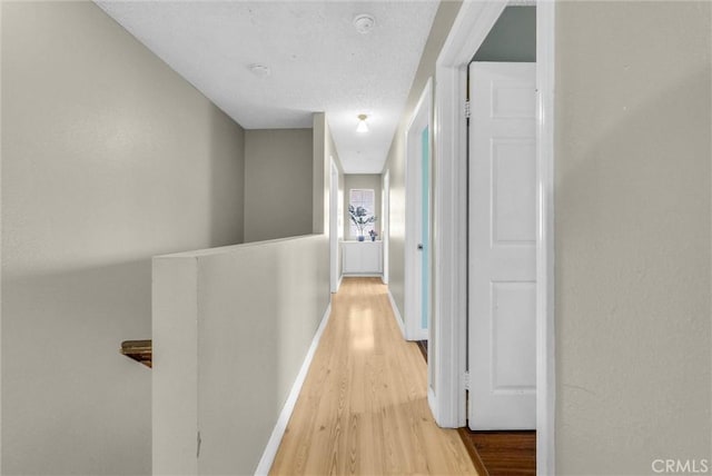 hall with wood finished floors and baseboards