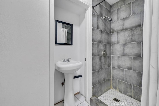 bathroom with a stall shower, tile patterned floors, and a sink