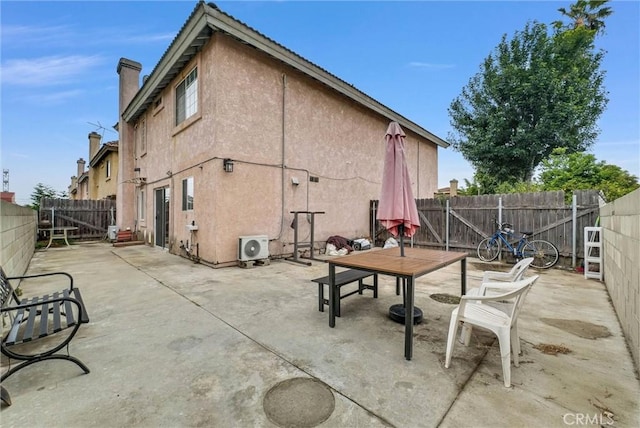 exterior space featuring a fenced backyard, a patio area, stucco siding, and a chimney