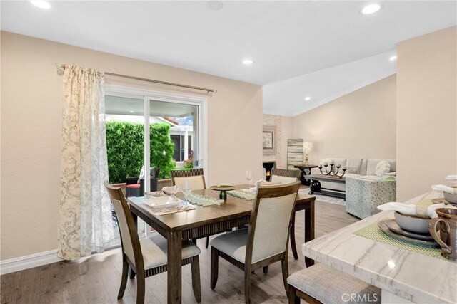 dining space featuring vaulted ceiling, light wood-style flooring, baseboards, and recessed lighting