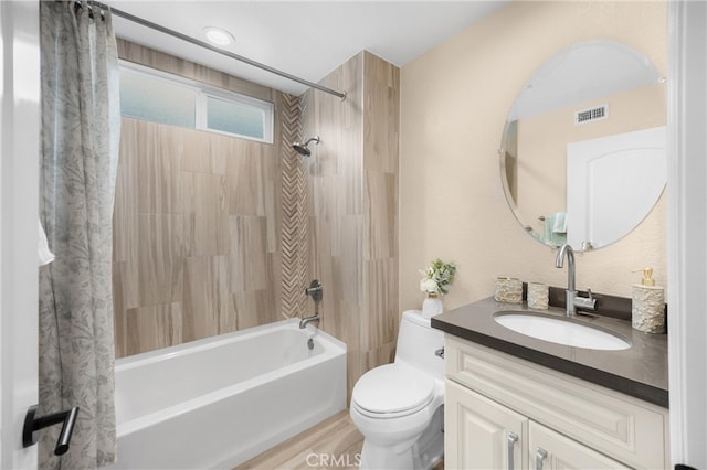 bathroom featuring toilet, visible vents, vanity, and shower / tub combo with curtain