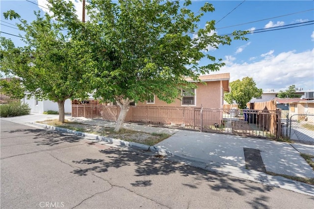 113 E White St, Barstow, CA 92311 - view of front facade with a fenced front yard, a gate, and stucco siding