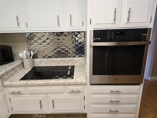 185 Avenida Majorca Unit A, Laguna Woods, CA 92637 - kitchen with black appliances, white cabinetry, and light countertops