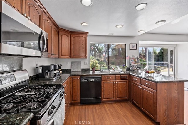 2757 Cape Dr, Corona, CA 92882 - kitchen featuring appliances with stainless steel finishes, wood finished floors, a peninsula, healthy amount of natural light, and recessed lighting