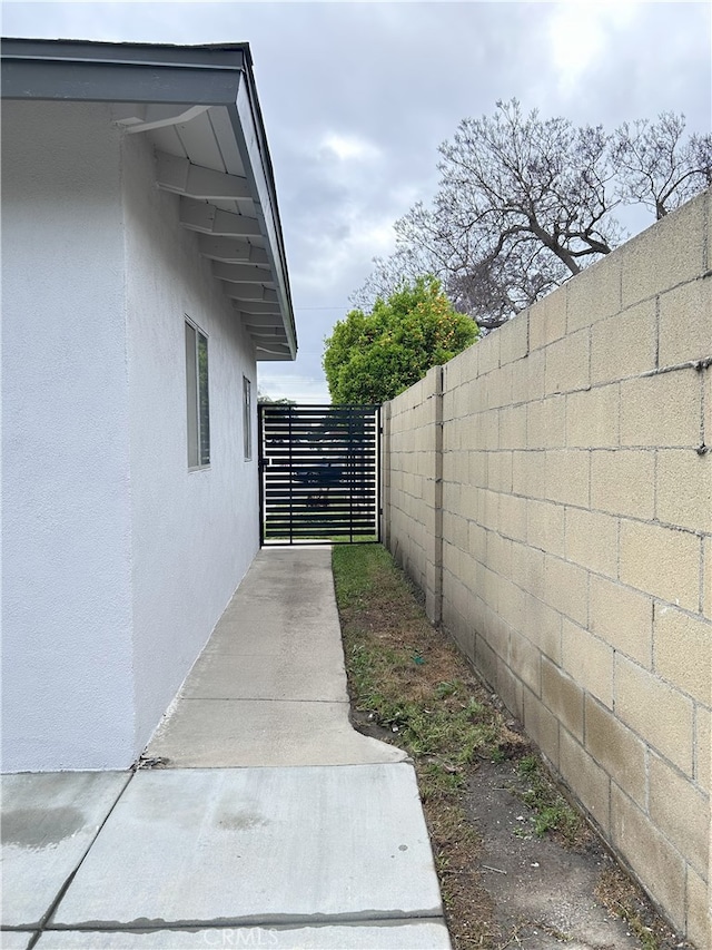 view of home's exterior with fence and stucco siding