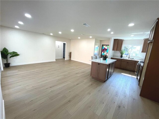 kitchen with a center island, light wood-style floors, open floor plan, recessed lighting, and light countertops