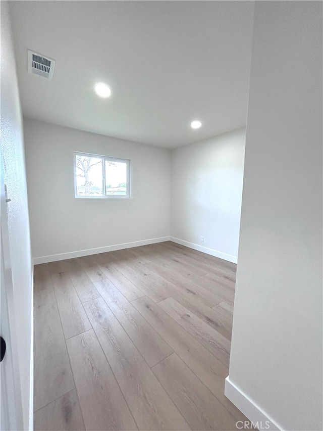 empty room featuring hardwood / wood-style flooring, recessed lighting, and baseboards