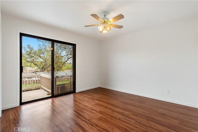empty room featuring baseboards, ceiling fan, and wood finished floors