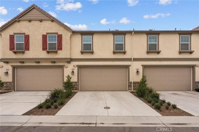 3981 E Huntington St, Ontario, CA 91761 - townhome / multi-family property with stone siding, stucco siding, a garage, and driveway