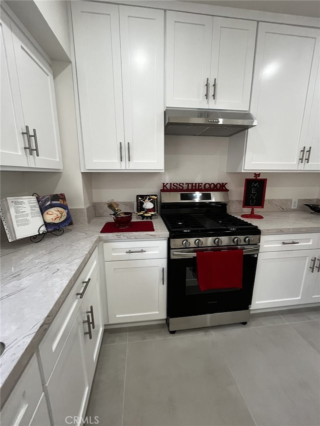 1449 W 45th St, Los Angeles, CA 90062 - kitchen featuring gas range, under cabinet range hood, light tile patterned floors, and white cabinetry