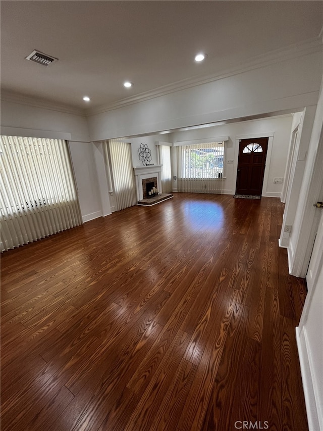 1449 W 45th St, Los Angeles, CA 90062 - unfurnished living room featuring crown molding, dark wood finished floors, a fireplace with raised hearth, recessed lighting, and baseboards