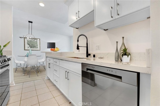 kitchen featuring light tile patterned floors, light stone counters, a sink, white cabinetry, and appliances with stainless steel finishes