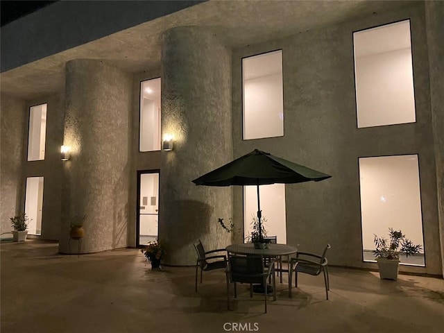 back of property featuring a patio area, outdoor dining space, and stucco siding