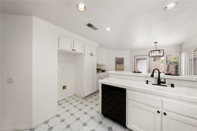kitchen with black dishwasher, light floors, visible vents, tile counters, and white cabinets