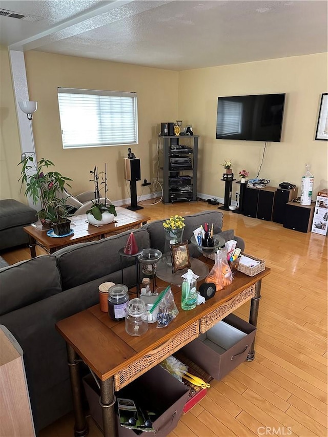 living room featuring visible vents and wood finished floors